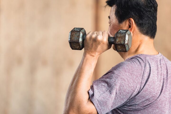 Man holding dumbbell by his shoulder