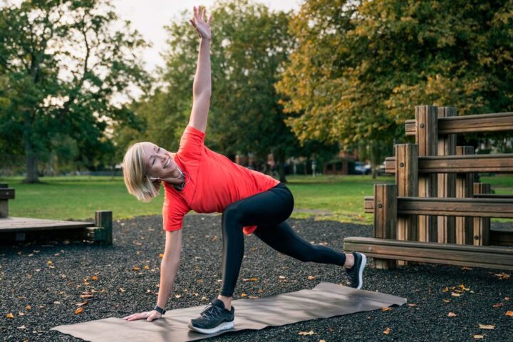 Woman performs thoracic rotation in park