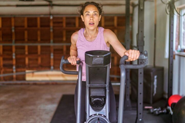 Woman riding air bike in garage
