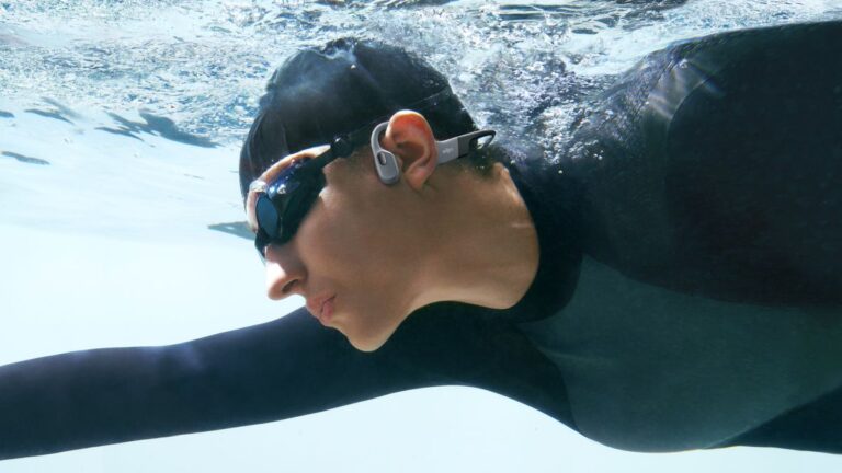 Swimmer wearing Shokz OpenSwim Pro headphones